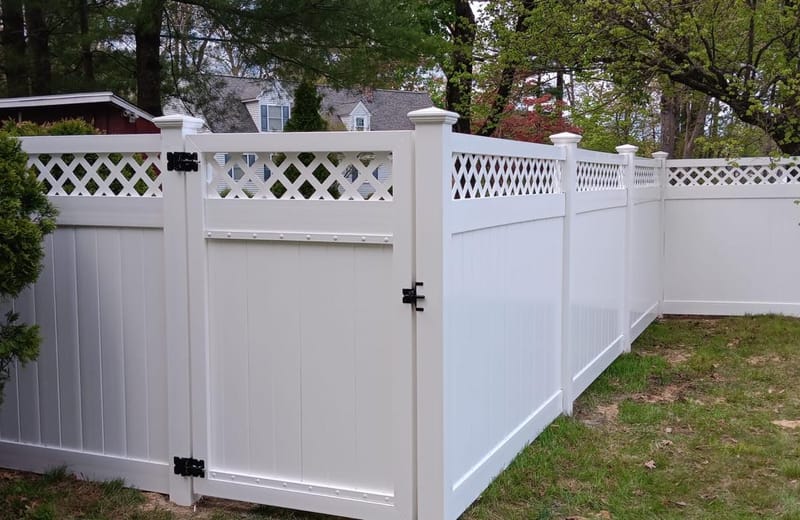 White vinyl gate with lattice top set into a matching privacy fence