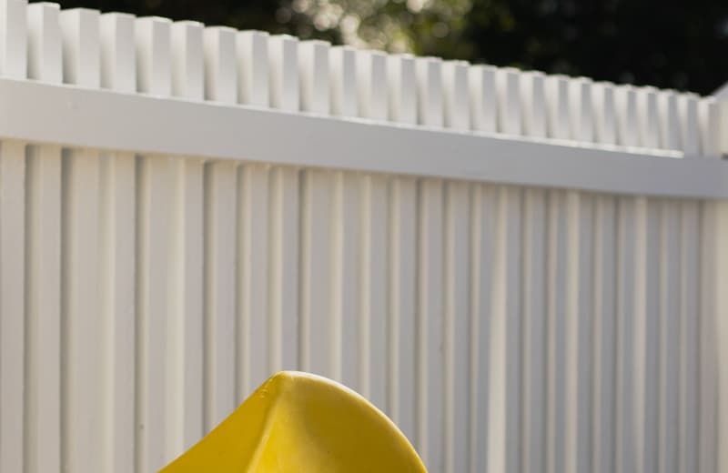 White vinyl privacy fence panels in a sunny backyard