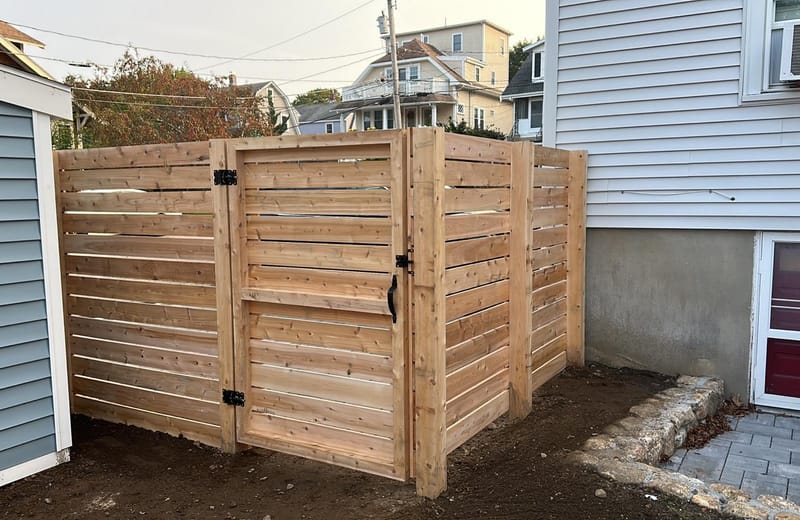 Horizontal cedar board enclosure with a custom gate
