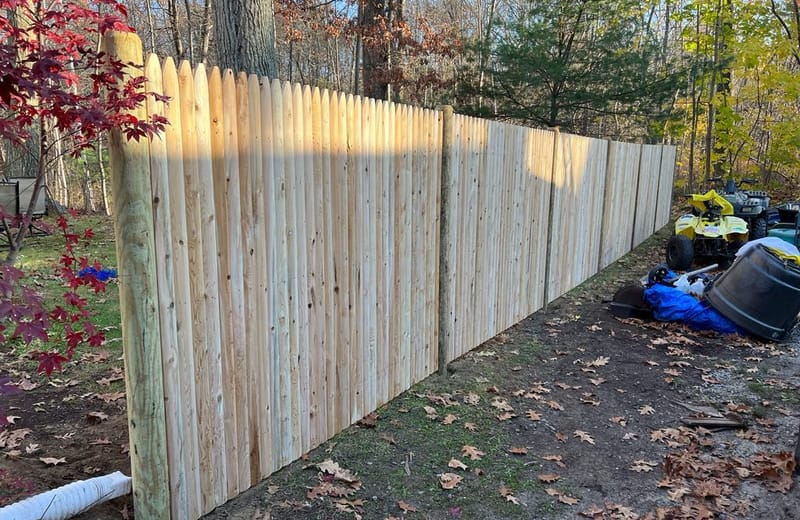 Natural cedar stockade privacy fence enclosing a backyard